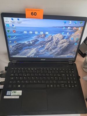 un ordinateur portable posé sur un bureau, à côté d'un téléphone