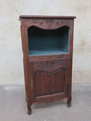 an old wooden cabinet with a glass door on top of it