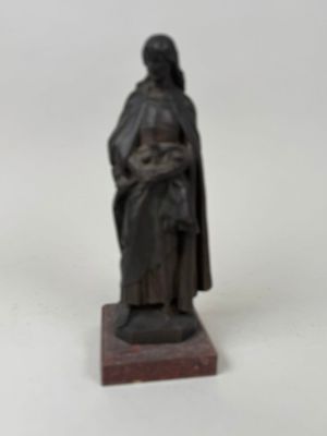 une statue représentant une femme vêtue d'une cape, posée sur un socle en bois