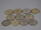 several different types of coins sitting on a white surface