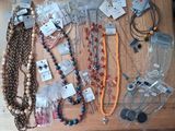 many necklaces and bracelets laid out on a table