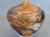 a glass vase with a brown and white swirl on it