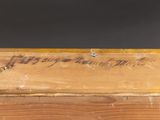 an old wooden box with writing on it sitting on top of a table