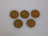 four gold coins sitting on top of each other on a white surface