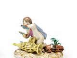 two figurines of a boy with a basket and a bird