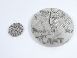 a silver coin and a silver coin on a white surface