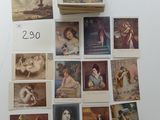 Plusieurs cartes postales anciennes représentant des femmes et des chats sont exposées sur une table