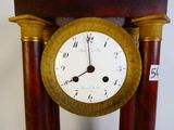 a clock that is sitting on a stand on the floor