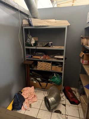 an image of a messy room with a shelf and a trash can