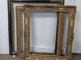 two antique gold picture frames sitting on the floor in front of a white wall
