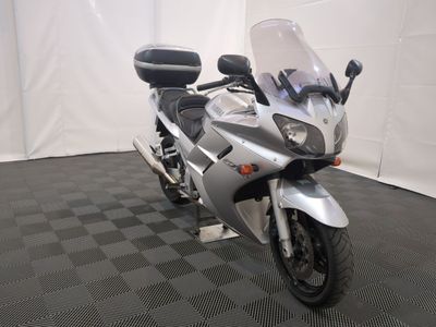 une moto argentée garée sur un sol à damier noir et blanc