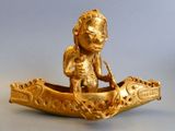 a gold figurine of a man in a boat