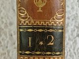 an old book sitting on top of a table next to a white wall