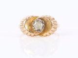 a close up of a gold ring with a white diamond