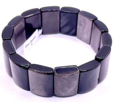 un bracelet noir muni d'une étiquette, posé sur une surface blanche