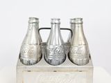 coca cola bottles in a wooden crate on a white surface
