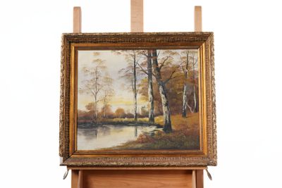 painting on easel of a landscape with a river and trees