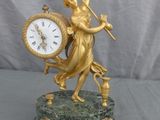 une statue de femme tenant une horloge sur une table