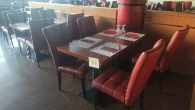 une table et des chaises dans un restaurant avec des chaises en cuir rouge
