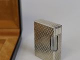 a silver lighter sitting on a table next to a box