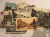 de nombreuses cartes postales anciennes représentant des bâtiments anciens, posées sur la table