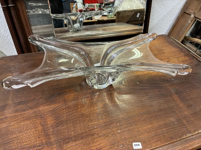 a glass bowl sitting on a table with a mirror in the background