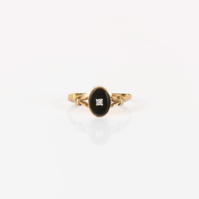 a gold ring with a black stone and a white diamond
