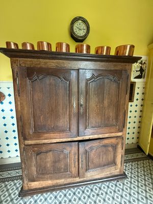 une grande armoire en bois surmontée de bougies
