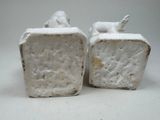 two white statues of animals that are on top of each other