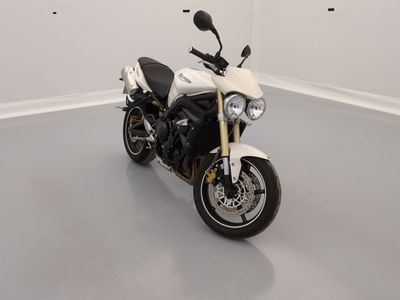 une moto blanche garée dans une pièce au sol gris