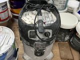 many buckets of paint sitting on a wooden table
