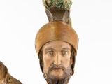 a wooden statue of a man with a hat on his head