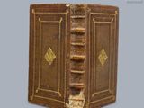 un vieux livre aux tranches dorées et à la couverture en cuir marron