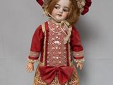 une poupée à l'ancienne, vêtue d'une robe rouge et d'un chapeau rouge