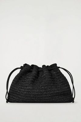 a picture of a black straw bag on a white background