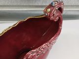 a red bowl sitting on a window sill next to a window sill
