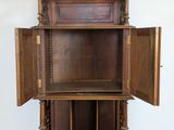 a wooden cabinet with a door open on a white wall