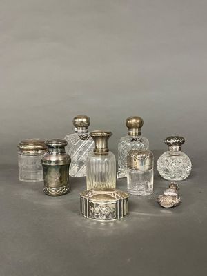un assortiment de flacons de parfum en argent et en verre posés sur une table