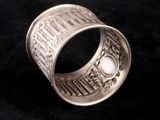 a close up of a silver ring on a black surface