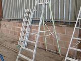 several ladders leaning up against a wall in a warehouse