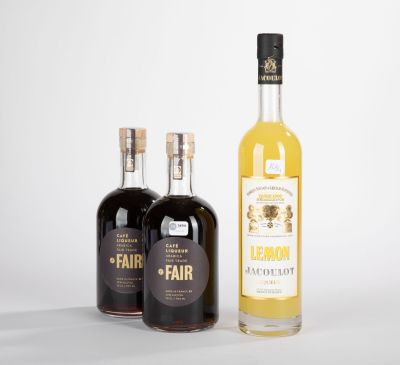 trois bouteilles de spiritueux de différentes sortes posées sur une surface blanche