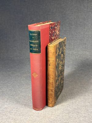 two books sitting on top of each other on a gray surface