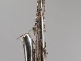 an image of a silver saxophone on a gray background