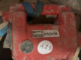 a red power drill sitting on top of a pile of junk