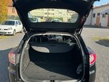 l'arrière d'une voiture dont le coffre est ouvert, sur un parking