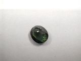 a green tourmaline stone on a white surface