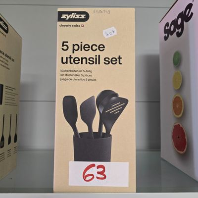 trois boîtes d'ustensiles posées sur une étagère dans un magasin