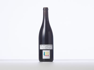 une bouteille de vin rouge posée sur une table blanche