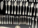 a lot of silver spoons and forks on the table
