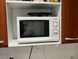 a microwave that is above a sink in a kitchen